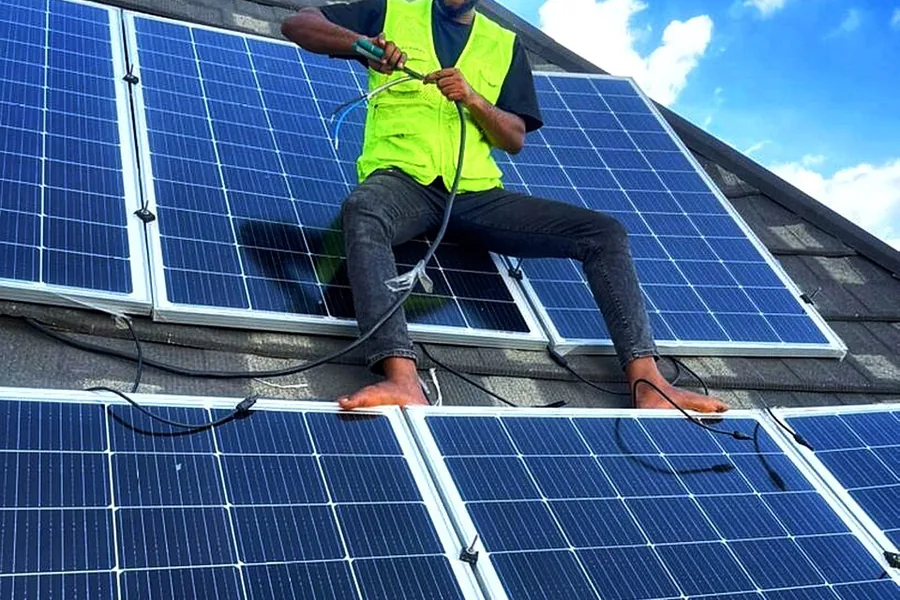 Technician connecting modules on a rooftop solar array